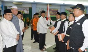 Plt.gubrnur Kepri saat memberikan Bendera merah putih pada Ketua rombongan Kloter Terakhir JCH Kepri