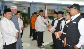 Plt.gubrnur Kepri saat memberikan Bendera merah putih pada Ketua rombongan Kloter Terakhir JCH Kepri