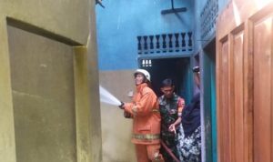 Anggota pemadam kebakaran Saat berusaha menyemprotkan Air untuk memadamkan api yang membakar atas dan Plafon Dapur kontrakan milik Syamsul di Keluarhan Kotra Piring