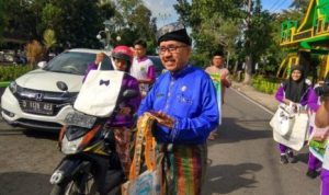 Kepala SMA Negeri V Tanjungpinang Yusserizal bersama siswanya saat membagi bagikan Tas Hasil karya siswanya ke Pengendara speda Motor di Jalan Pamedan Tanjungpinang.