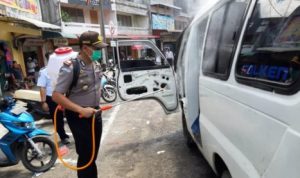 Cegah wabah Virus Corona Polisi Menyemprotkan Cairan Disinfektan ke sejumlah angkot di Jalan Merdeka Tanjungpinang