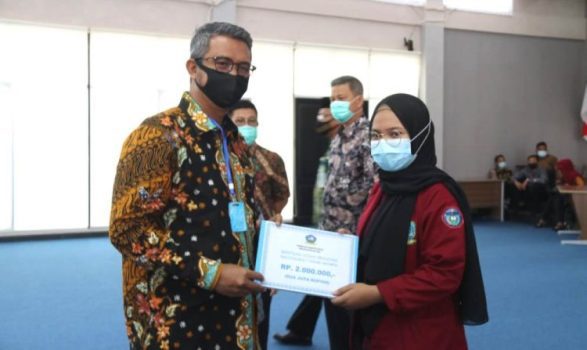 Bupati Bintan Apri Sujadi saat menyerahkan Bantuan Beasiswa pada mahasiswa asal Bintan