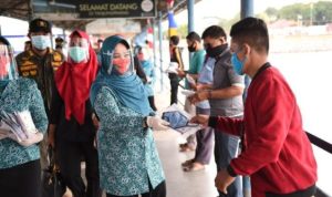 Ketua tim Pengerak PKK Kepri Hj.Meri Isdianto saat membagi bagikan masker di Pelabuhan Sri Bintan Pura Tanjungpinang