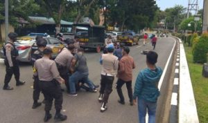 Anggota Polisi saat membubarkan aksi Unjuk Rasa mahasiswa dan menangap mahasiswa