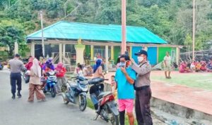 Salah satu petugas polisi di Tambelan memakaikan masker kepada warga yang ditemui di jalan