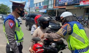 Anggota Satlantas Polres Tanjungpinang saat memakaikan Masker pada Anak Pengendara dalam Operasi Zebra Seligi 2020