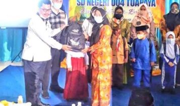 Kepala dinas pendidikan Bintan Tamsir saat membagikan Seragam dan Peralatan Sekolah Gratis pada Orang Tua siswa di SDN 004Toapaya Bntan