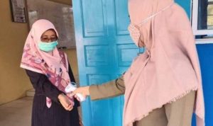 Terapakan Protokol Kesehatan salah seorang guru di SMPN 23 Satap Kecamatan Mantang dilakukan pengukuruansuhu badan dengan Termogan Foto Istimewa