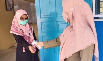 Terapakan Protokol Kesehatan salah seorang guru di SMPN 23 Satap Kecamatan Mantang dilakukan pengukuruansuhu badan dengan Termogan Foto Istimewa
