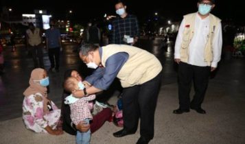 Plh Gubkepri TS Arif Fadillah saat memantau kondisi Laman Gurindam 12. Arif berkesempatan memakaikan masker pada seorang bocah pengunjung taman.