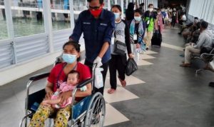 Seorang Ibu yag merupakan PMI yang dideportasi Malaysia dibantu mengggnakan Kusri Roda saat tba di Pelabuhan Sri Bintan Pura Tanjungpinang