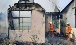Anggota Pemadam kebakaran dari Damkar kota Tanjungpinang masih memadamkan sisa Api yang menghanguskan dua unit rumah