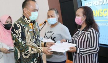 Dirjen Dukcapil Kemendagri Prof. Zudan Arif Fakhrulloh memberikan dokumen KK pada warga Tangerang Selatan.