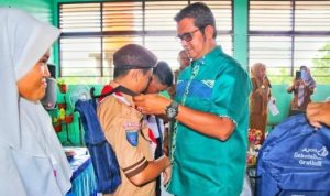 Bupati Bintan Apri Sujadi menyematkan lencana pramuka pada salah seorang Penggalang Pramuka di Bintan baru baru ini.