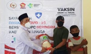 Anggota DPRD Lingga Tengku Azwar saat membagikan sembako beras pada warga yang melakukan vaksinasi di Lingga
