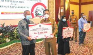 Gubernur Kepri Ansar Ahmad Saat menyerahkan secara simbolis Bantuan Sosial pada masyarakat kurang mampu dan Terdampak serta terkonfirmasi Covid 19 di Tanjungpinang