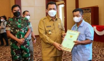 Gubernur Ansar menyerahkan sertifikat tanah kepada salah satu warga