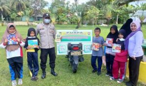Anggota Satuan Binmas Polres Lingga bersama sejumlah siswa SD dengan Motor Pustaka Keliling mendatangi Sekolah Dasar Negeri 007 Pasir Putih Kelurahan Dabo kecamatan Singkep-Lingga