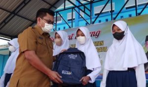 Kepala dinas Pendidikan Bintan Tamsir saat menyerahkan bantuan Tas dan keperluan sekolah lain pada siswa di Bintan (foto:Hasura/Bintan)