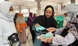 Petugas memberikan masker kepada jemaah haji Indonesia di Kota Madinah, Arab Saudi. (Foto-Kemenag)