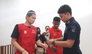 Terdakwa Dekky saat dipsangkan borgol oleh Petugas Kejaksaan usai menjalani persidangan. (Foto: Roland/Presmedia)