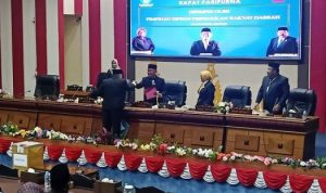 Anggota DPRD Bintan Muhammad Toha menyerahkan berkas pengunduran diri dari Anggota Panlih ke Ketua DPRD Bintan Agus Wibowo dalam sidang paripurna Pilwabup Bintan. (Foto: Hasura/Presmedia.id)
