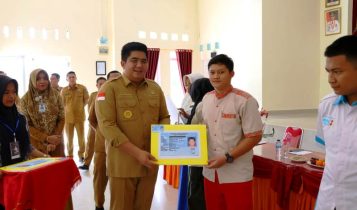 Bupati Bintan Roby Kurniawan menyerahkan secara simbolis e-KTP ke siswa SMKN 1 Bintan. (Foto: Diskominfo/Presmedia.id)