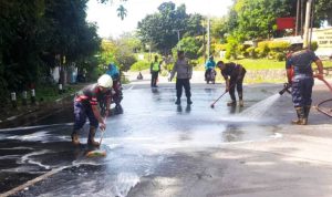Petugas UPT Damkar Bintan Utara membersihkan tumpahan solar di Jalan Taman Sari. (Foto: UPT Damkar/ Presmedia.id)
