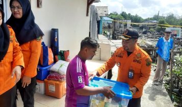 Kepala Pelaksana BPBD Kota Tanjungpinang Muhammad Yamin saat memberikan bantuan kepada korban. (Foto: Roland/Presmedia.id)