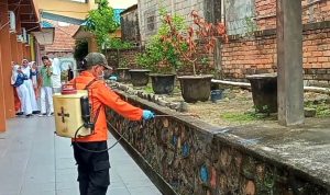 Petugas BPBD saat melakukan penyemprotan disinfektan di SMPN 1 Tanjungpinang. (Foto: Roland/ Presmedia.id)