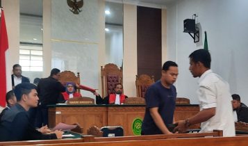 Terdakwa Kaswan Khomzi Baju kaos biru meninggalkan persidangan di PN Tanjungpinang Terdakwa Kaswan Khomzi (Baju kaos biru) meninggalkan persidangan di PN Tanjungpinang. (Foto: Roland/Presmedia.id)
