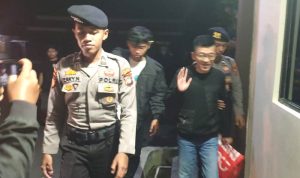 Ditahan Polres Bintan, Hasan digiring epat polisi berjalan kaki membawa kantong merah ke sel tahanan Polres Bintan. (Foto:Hasura)