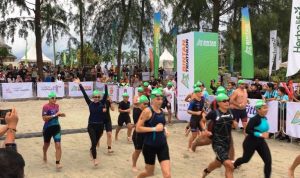Istri Wabup Bintan Sabine Rohden melambaikan tangan saat mengikuti rintangan berenang dalam event Bintan Triathlon 2024 di Lagoi Bay, Bintan. (Foto: Hasura/Presmedia.id)