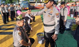 Kapolresta Tanjungpinang Kombes Pol Heribertus Ompusunggu saat prosesi siram kembang kepada personel yang naik pangkat di lapangan Apel Mapolresta Tanjungpinang. (Foto: Roland/Presmedia.id)