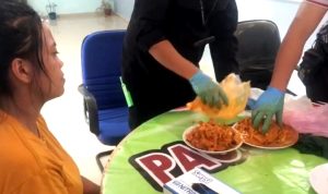 Wanita terduga D dan rekannya CÂ  yang menyelundupkan empat paket sabu ke Lapas, menyeksikan lauk sotong sambal yang dibawanya digeledah dan diperiksa Polisi. (Foto: Hasura/Presmedia.id)