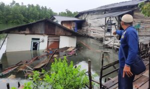Ketua RT 03 RW 07 Kelurahan Melayu Kota Piring Kecamatan Tanjungpinang Timur, Nasrun saat menunjuk rumah warga yang tenggelam. (Foto: Roland/Presmedia.id)