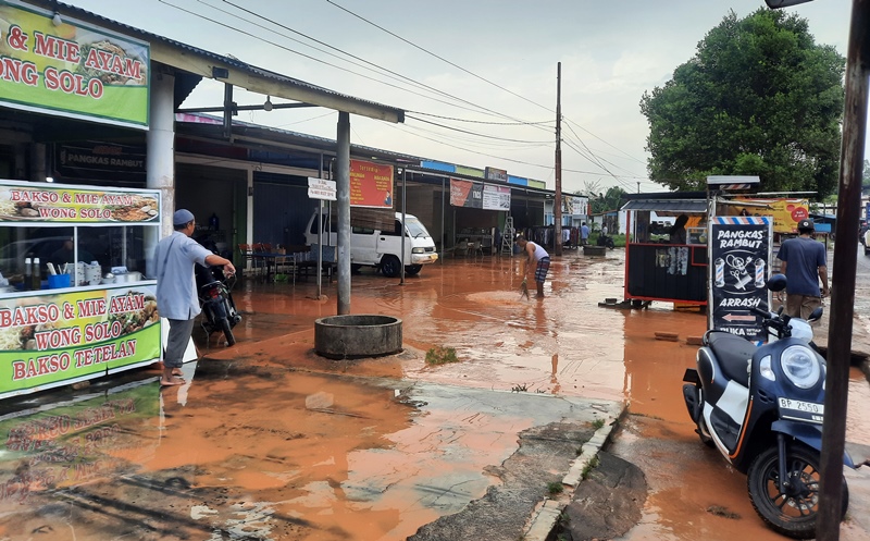 Sejumlah pemilik kios di Jalan Nusantara membersihkan lumpur tanah merah akibat banjir Sejumlah pemilik kios di Jalan Nusantara membersihkan lumpur tanah merah akibat banjir. (Foto: Roland/Presmedia.id)