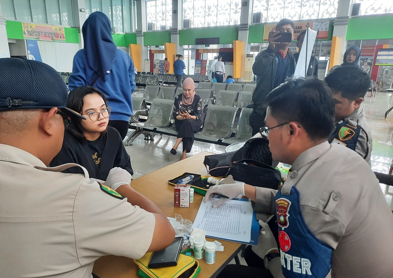 Dokter Kesehatan Polresta Tanjungpinang memberikan layanan cek kesehatan dan pengobatan gratis kepada calon penumpang selama perayaan natal dan tahun baru 2025 di Pelabuhan Sri Bintan Pura (SBP) Tanjungpinang (Roland/Presmedia).