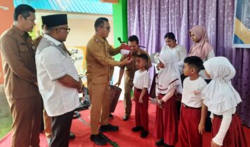 PJ Walikota Tanjungpinang membagikan seragam gratis secara simbolis di SMPN 1 Tanjungpinang. (Foto: Roland/Presmedia.id)