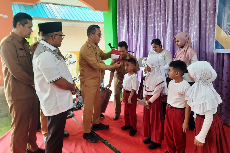 PJ Walikota Tanjungpinang membagikan seragam gratis secara simbolis di SMPN 1 Tanjungpinang. (Foto: Roland/Presmedia.id)