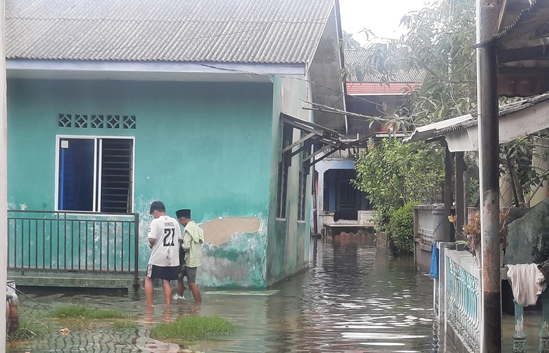 Dua orang anak saat sedang bermain di Banjir Rob Jalam Akasia Tanjungpinang (Roland/ presmedia.id)