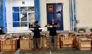 Dua pelaku penyelundupan rokok ilegal asal Batam As (26) dan Sb (41) saat menunjukan Rokok selundupannya yang diamankan BC Langsa. (Foto: BC Langsa)