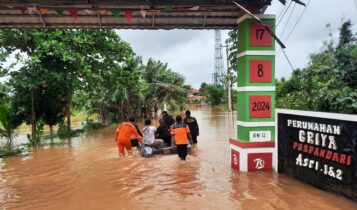 Petugas BPBD saat menyisir perumahan yang terendam banjir. (Foto: Roland/Presmedia.id)