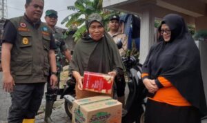 Sekda Bintan Ronny Kartika dan Kalaksa BPBD Bintan Ramlah menyerahkan bantuan logistik kepada korban terdampak bencana alam. (Foto: BPBD Bintan)