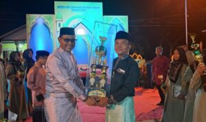 Camat Bintan Timur Indra Gunawan menyerahkan piala bergilir MTQ dan Hadist 2025 ke Lurah Kijang Kota Daniel Pardomuan Hasibuan. (Foto: Hasura/Presmedia.id)