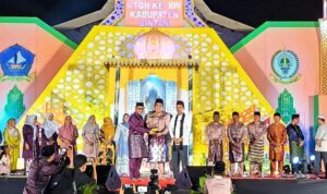 Bupati Bintan Roby Kurniawan didampingi Ustadz Abdul Somad menyerahkan Piala Bergilir Juara Umum kepada Camat Bintan Timur Indra Gunawan dalam penutupan MTQH ke XIV Tingkat Kabupaten Bintan di Astaka Gedung Nasional Tanjung Uban. (Foto: Hasura/Presmedia.id)