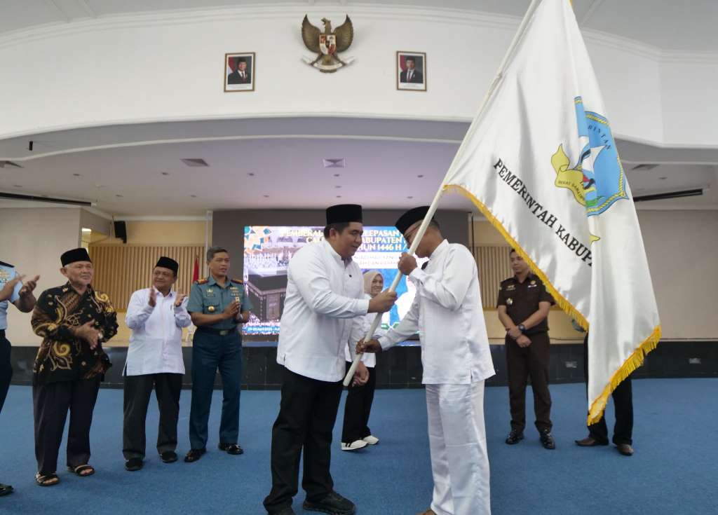 Bupati Bintan Roby Kurniawan saat menyerahkan bendera kontingen ke Calon Jamaah Haji asal Kabupaten Bintan 2025.