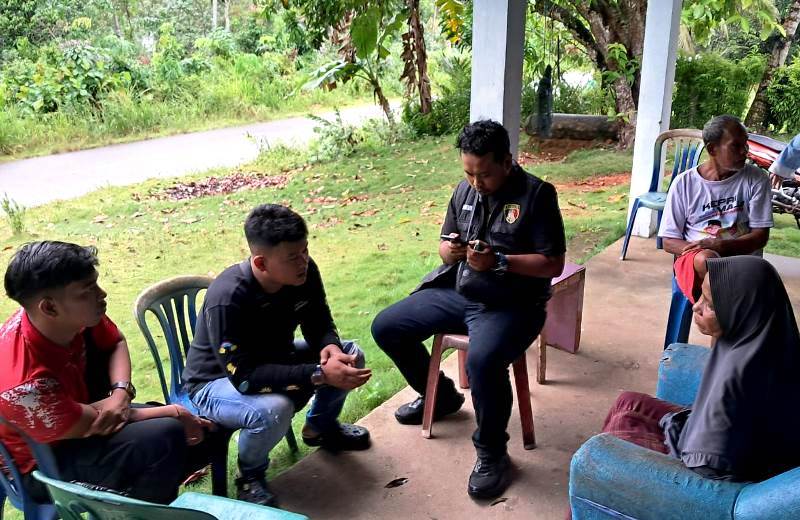 Penyidik Reskrim Polsek Bintan Timur sedang memintai keterangan ibu korban di rumah duka Bangun Rejo RT 003/RW 002. (Foto: Hasura/Presmedia.id)