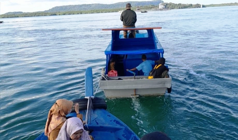Pompong yang mengangkut Guru SMP ditunda atau ditarik oleh Pompong yang mengangkut Guru SD di Tengah Perairan Sei Enam-Selat Limau. (Foto: La Judin)
