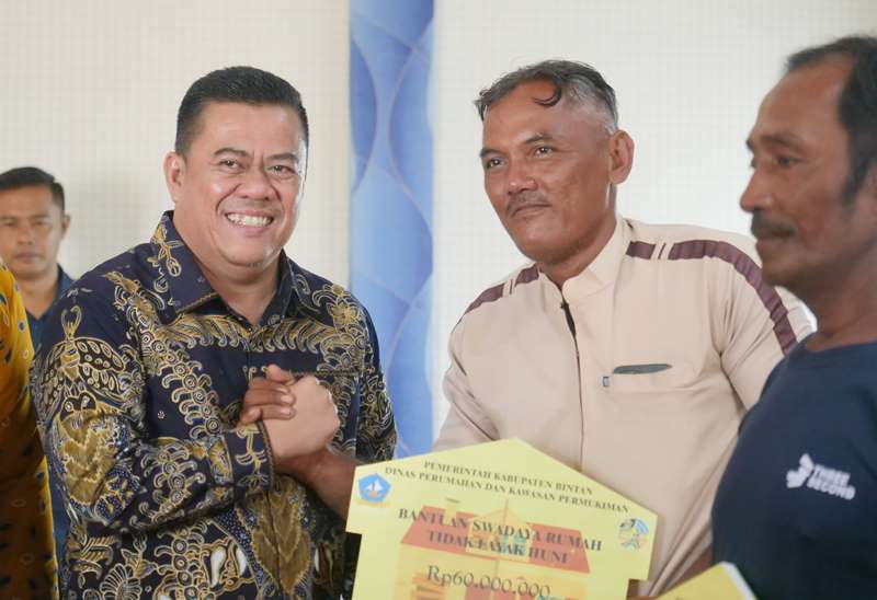 Sekda Kabupaten Bintan Rony Kartika menyerahkan anggaran program BSRTLH 2025 kepada warga penerima di Bintan.